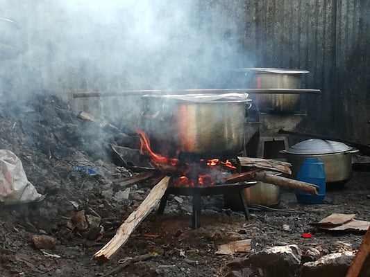 grey metal cooking pot on burning wood
