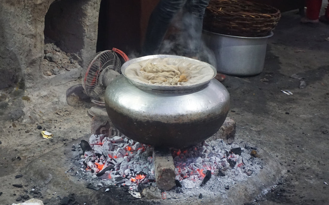 a large metal pot sitting on top of a fire