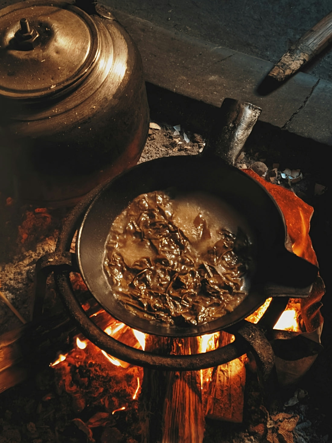 Tea is brewing over a fire.
