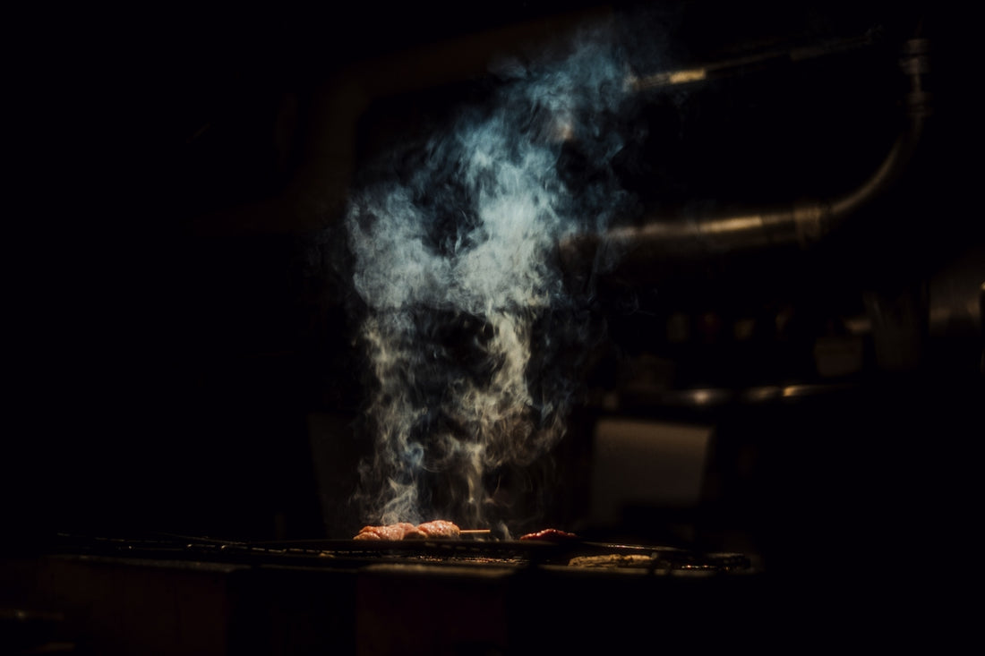 Smoke rising from food cooking on a grill.